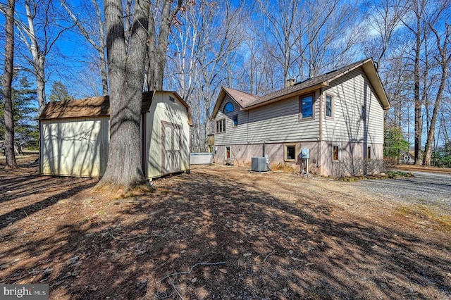 view of side of property featuring a storage shed, an outdoor structure, and central air condition unit