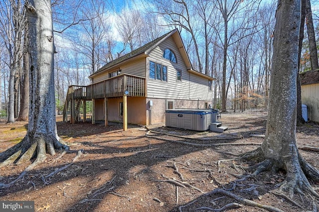 view of side of property featuring a hot tub, central AC, and a wooden deck