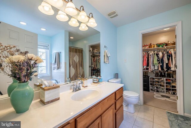 bathroom with tile patterned flooring, vanity, walk in shower, and toilet