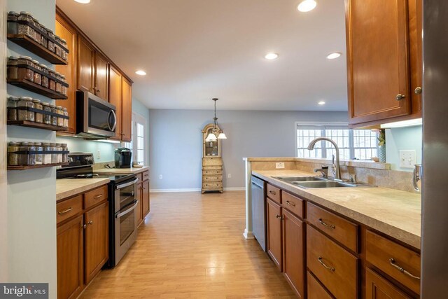 kitchen featuring stainless steel appliances, plenty of natural light, sink, and pendant lighting