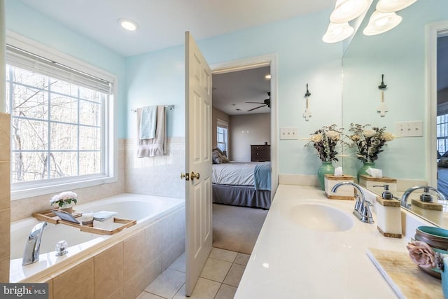 bathroom featuring tiled tub, vanity, and tile patterned floors