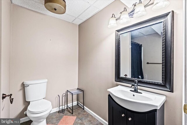 bathroom with vanity, a paneled ceiling, and toilet