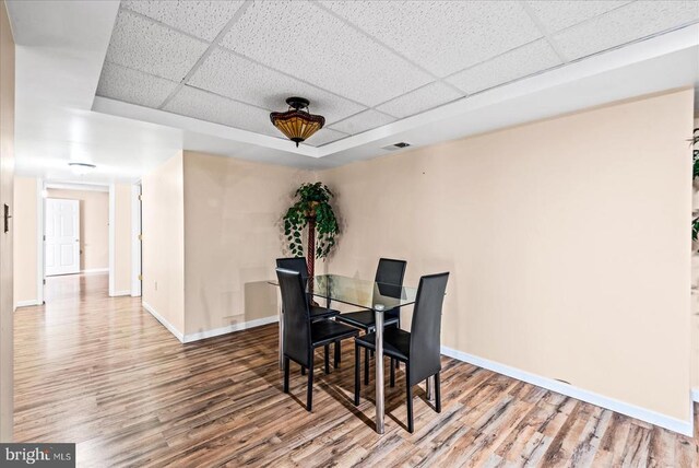 dining room featuring a drop ceiling and hardwood / wood-style floors