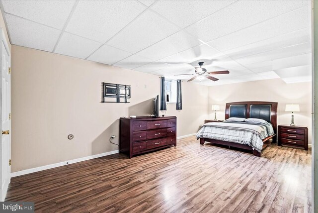 bedroom featuring ceiling fan, a paneled ceiling, and light hardwood / wood-style flooring