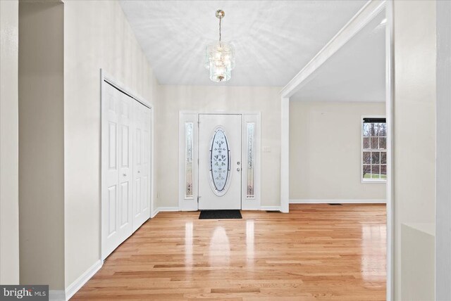 entryway featuring hardwood / wood-style flooring and a notable chandelier