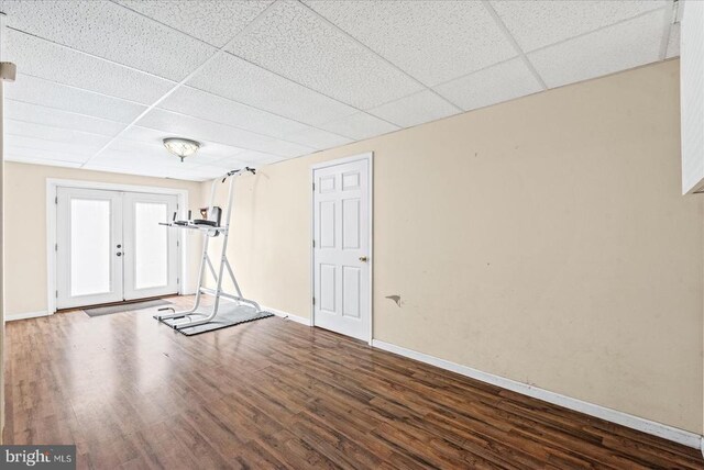 workout room with french doors, a paneled ceiling, and dark hardwood / wood-style flooring