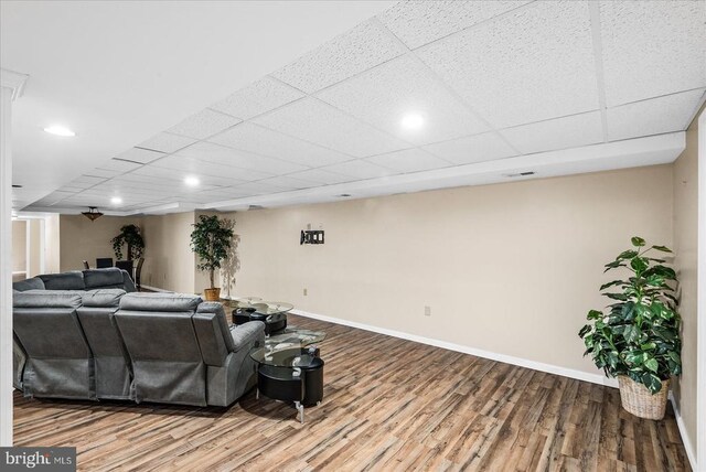 living room featuring hardwood / wood-style floors and a drop ceiling