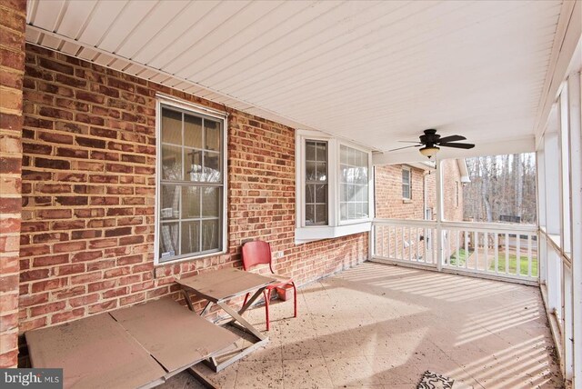 unfurnished sunroom with ceiling fan