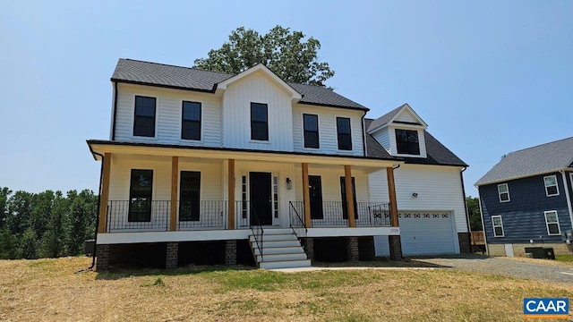 modern farmhouse with a garage, central air condition unit, covered porch, and a front lawn