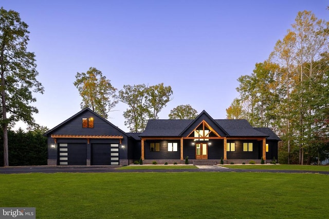 modern farmhouse style home with aphalt driveway, a front lawn, and a garage