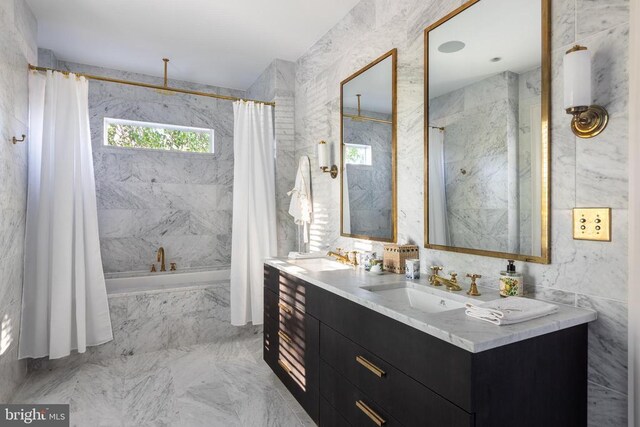 full bath featuring a combined bath / shower with rainfall shower, marble finish floor, a sink, and double vanity