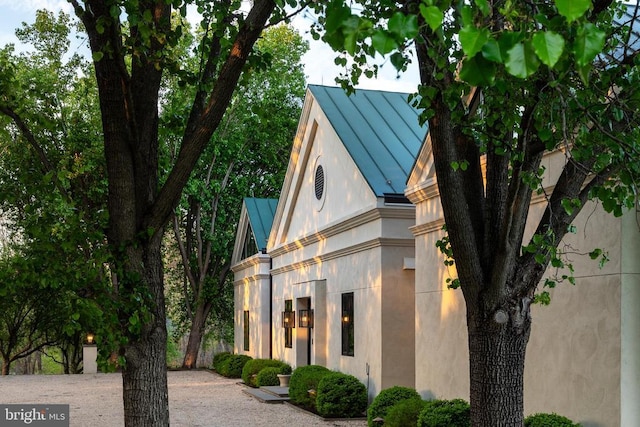 view of front of property featuring stucco siding, a standing seam roof, and metal roof