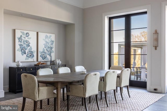 dining space with french doors, wood finished floors, and baseboards