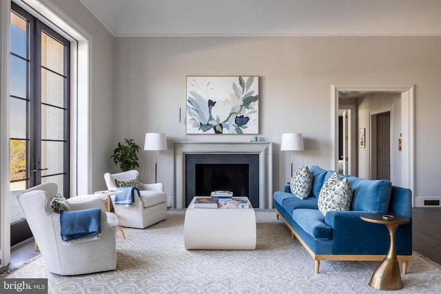 living area with crown molding, visible vents, and a fireplace