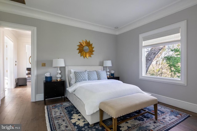bedroom with crown molding, wood finished floors, and baseboards