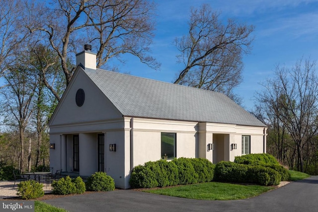 view of front of property featuring stucco siding and a chimney