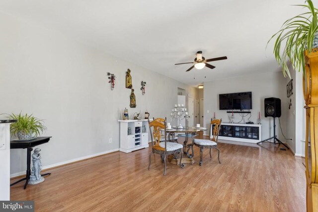 dining room with baseboards, a ceiling fan, and light wood-style floors