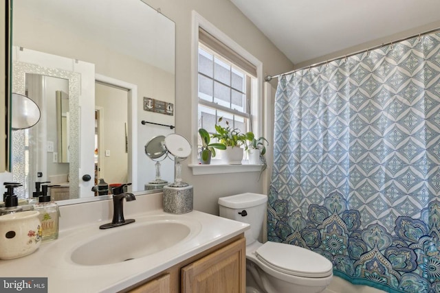 bathroom featuring toilet, curtained shower, and vanity