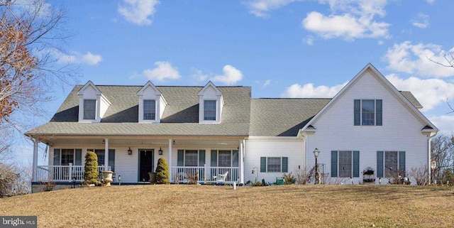 view of front of property featuring covered porch, a shingled roof, and a front yard