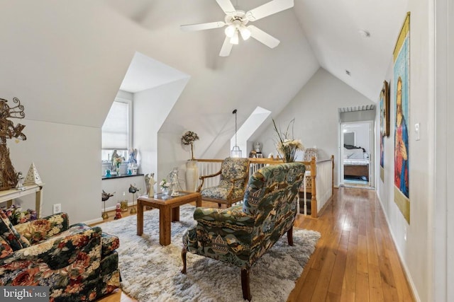 living area with lofted ceiling, light wood-style floors, and baseboards