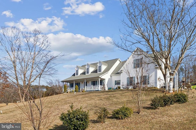 cape cod house with covered porch and a front lawn