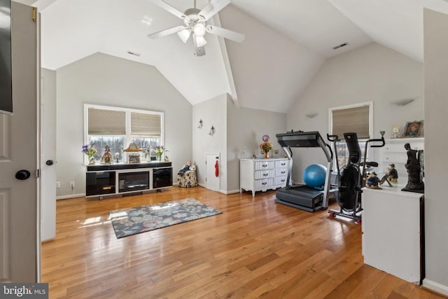 workout room featuring high vaulted ceiling, wood-type flooring, and visible vents