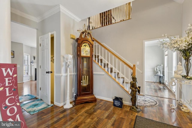 entrance foyer with baseboards, stairway, dark wood finished floors, and crown molding