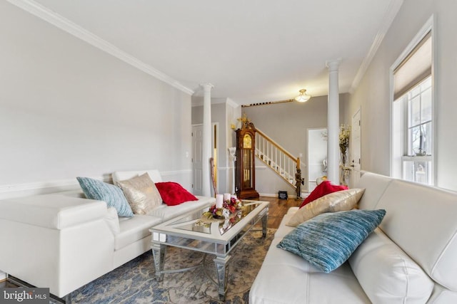 living room with decorative columns, stairs, and crown molding