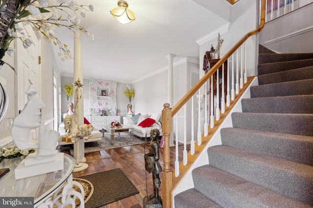 interior space with decorative columns, stairs, crown molding, and wood finished floors