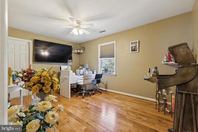 office space featuring visible vents, ceiling fan, light wood-style flooring, and baseboards