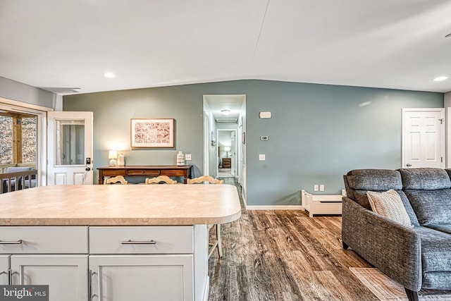 kitchen featuring baseboards, open floor plan, dark wood-style flooring, light countertops, and white cabinetry