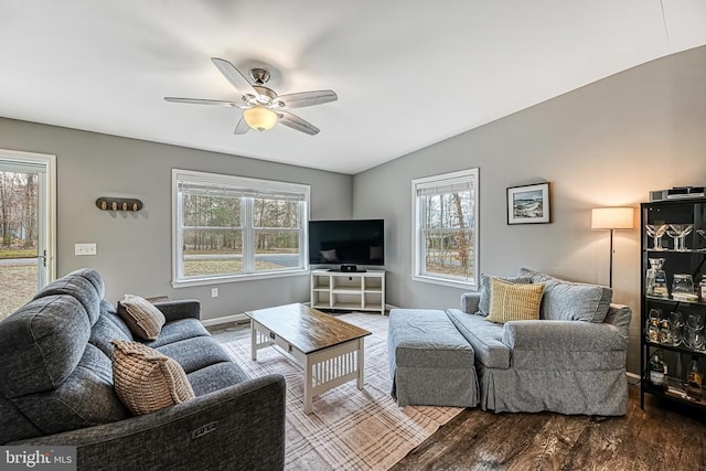 living area featuring ceiling fan, baseboards, vaulted ceiling, and wood finished floors