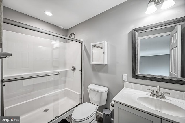 full bath with a stall shower, vanity, and toilet