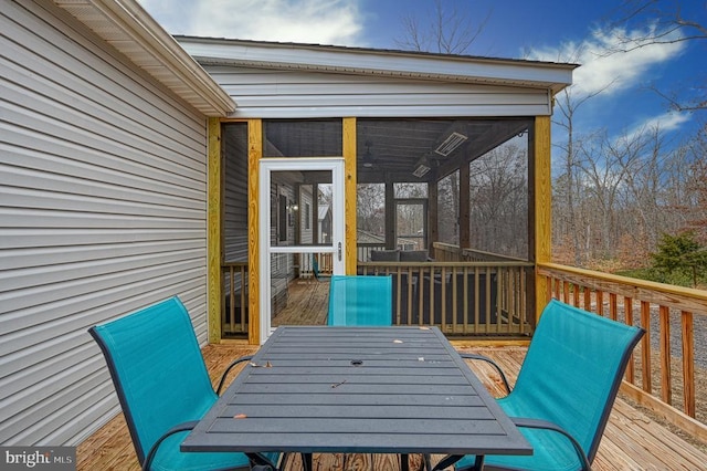 wooden deck featuring outdoor dining space and a sunroom