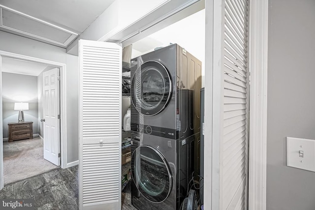 laundry room with laundry area, carpet flooring, stacked washer and clothes dryer, and baseboards