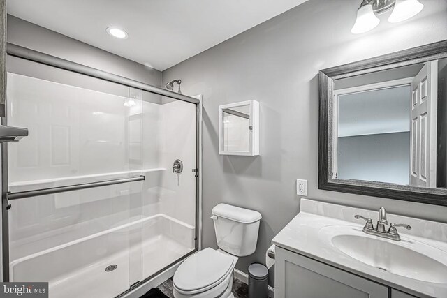 full bath featuring toilet, a shower stall, and vanity