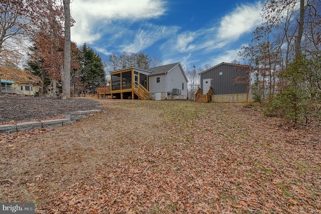 rear view of property with entry steps and a sunroom