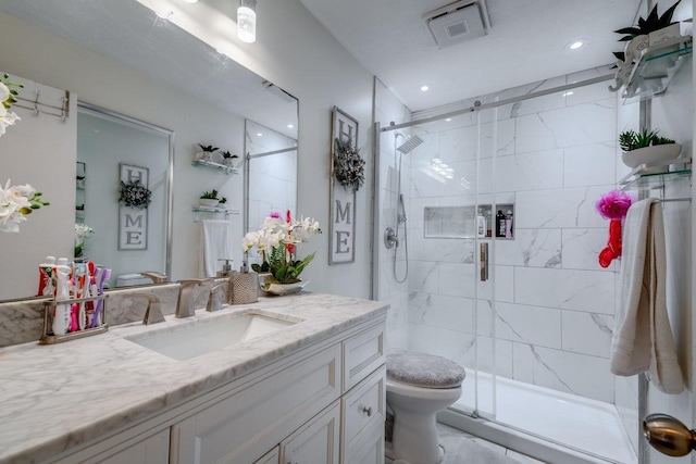 bathroom with vanity, toilet, and a shower with door