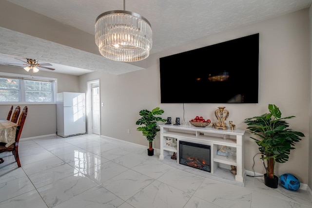 living room featuring ceiling fan with notable chandelier and a textured ceiling