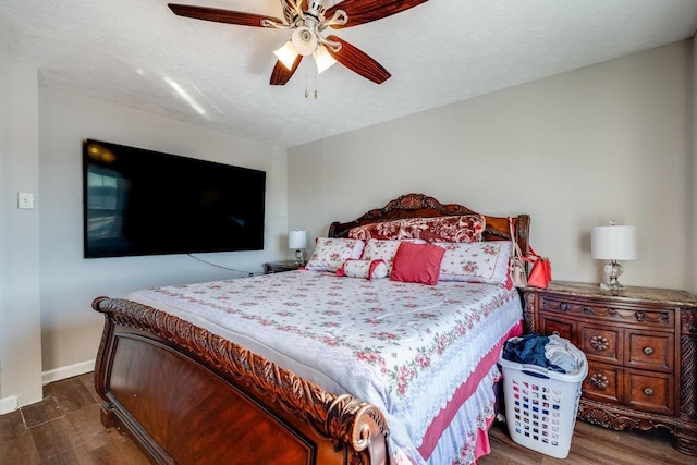 bedroom featuring ceiling fan, dark hardwood / wood-style flooring, and a textured ceiling