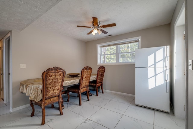 dining room featuring ceiling fan and a textured ceiling