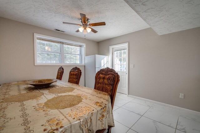 dining room with a textured ceiling and ceiling fan