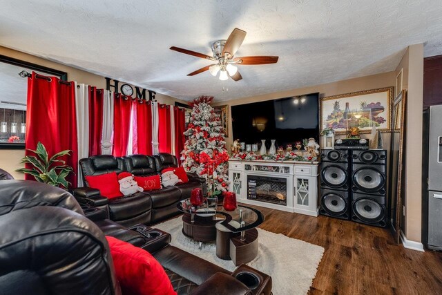 living room featuring washer / clothes dryer, ceiling fan, dark wood-type flooring, and a textured ceiling