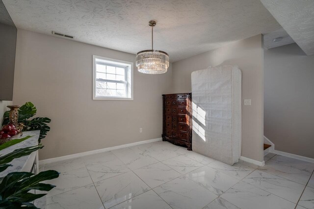 interior space featuring a notable chandelier and a textured ceiling