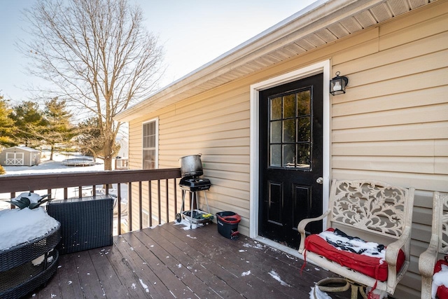 snow covered property entrance with a deck