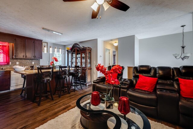 living room with ceiling fan, dark hardwood / wood-style flooring, and a textured ceiling