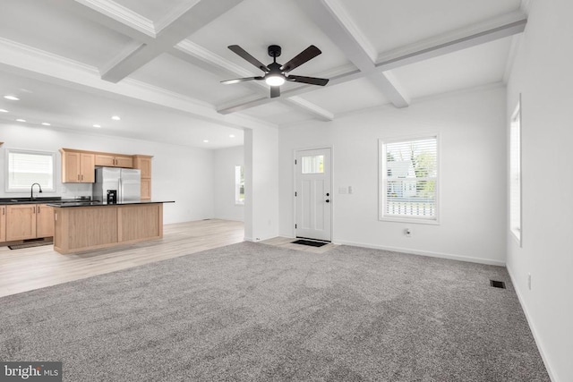 unfurnished living room featuring beamed ceiling, a sink, coffered ceiling, recessed lighting, and a ceiling fan