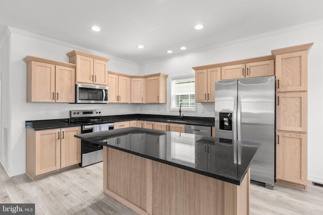 kitchen featuring appliances with stainless steel finishes, light brown cabinets, crown molding, and a sink