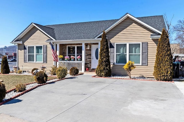 view of front of house featuring stone siding, a shingled roof, and a porch