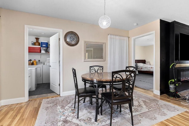 dining space with washer and dryer, light wood-style flooring, and baseboards